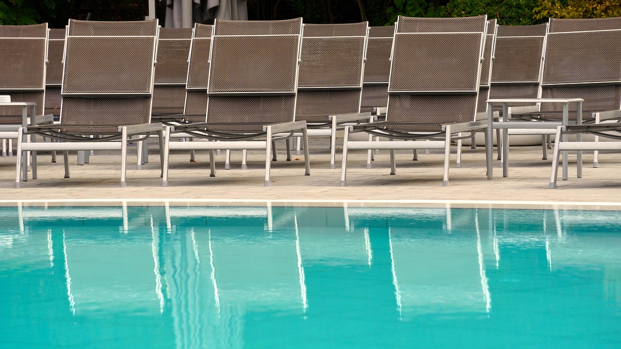 Lounge chairs lined up along a pool deck